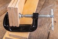 Metal wood clamp on a workshop table. Carpentry accessories in a wood workshop