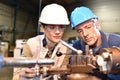 Metal worker teaching apprentice the skills