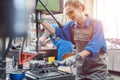 Metal worker woman operating drilling machine