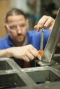 Worker using electric wheel grinding on steel structure in factory Royalty Free Stock Photo