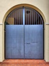 Metal yard door with arch and grating.