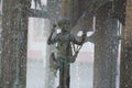 Metal young kid statue playing among rain water drop at mainz, Germany