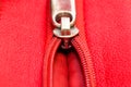 Metal zipper on intense red leather jacket or purse detail close up macro. The zipper is partly open and binding together Royalty Free Stock Photo