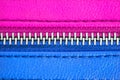 Metal zipper tightly closed binding together two leather layers in pink and blue colours. Concept for male female gender man woman