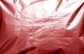 Metalized plasrtic wrap texture with crumples in red tone Royalty Free Stock Photo