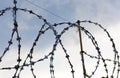 Metallic barbed wire on the wall on sky background Royalty Free Stock Photo