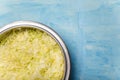 Metallic bowl of cabbage cut into thin strips on blue painted wooden background. Vegetarian, organic, healthy food, diet,