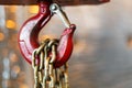 Metallic chain handle with red hook in technical room. Crane cargo hook