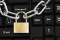 Metallic chain with a locked padlock on a computer keyboard Royalty Free Stock Photo