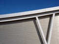 Metallic cladding on modern industrial building with steel girders and curved roof beam against a blue sky Royalty Free Stock Photo