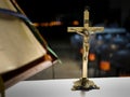 Metallic cross placed on an altar before a catholic mass at night with blurred background