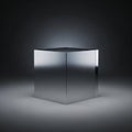 A metallic cube rests on a gray surface illuminated against a dark background Royalty Free Stock Photo
