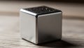 A metallic cube with a smooth reflective surface rests on a wooden tabletop Royalty Free Stock Photo