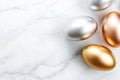 Metallic easter eggs in gold, silver, and bronze on marble surface for elegant holiday decor Royalty Free Stock Photo