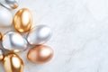 Metallic easter eggs in gold, silver, and bronze on marble surface for elegant holiday decor Royalty Free Stock Photo