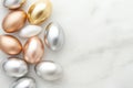 Metallic easter eggs in gold, silver, and bronze on marble surface for elegant holiday decor Royalty Free Stock Photo