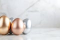 Metallic easter eggs in gold, silver, and bronze on marble surface for elegant holiday decor Royalty Free Stock Photo