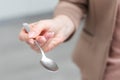 Metallic empty eating spoon in a human right hand with clipping path isolated on white Royalty Free Stock Photo