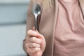Metallic empty eating spoon in a human right hand with clipping path isolated on white Royalty Free Stock Photo