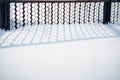 Metallic fence casts a shadow on the pure white snow. Calmness in the park after snowfall. Abstract winter background Royalty Free Stock Photo