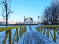 Metallic footbridge by river Sysa and homes in winter, Lithuania Royalty Free Stock Photo