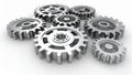 Metallic gears interlocking on a white surface, representing teamwork and industry. Royalty Free Stock Photo