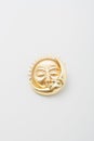 Metallic golden brooch in shape of sun and moon with faces. Spiritual esoteric symbol, astrological boho sign, pin on white