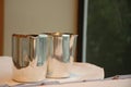 Metallic jugs on white table