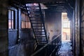 Metallic ladder in a dilapidated and half-dark dirty factory with stone walls