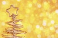 Metallic modern christmas tree on golden tint light bokeh background, xmas holiday Royalty Free Stock Photo