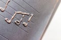 Metallic musical notes and a treble clef on a stave on a notebook background
