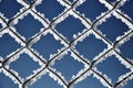 Metallic net covered with hoarfrost. Extreme cold weather concept