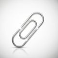A metallic paperclip is placed against a soft, gradient background, casting a subtle Royalty Free Stock Photo