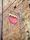 Metallic plaque of a Medieval Embattled Shield on a brick facade. Asti, Piedmont, Italy Royalty Free Stock Photo