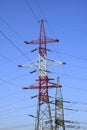 Metallic pylons of high-voltage power lines against a blue sky Royalty Free Stock Photo