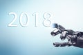 Metallic robot hand touches date of new year 2018. Royalty Free Stock Photo