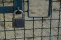 Metallic silver-colored padlock on the fence close-up. Lock and chain Royalty Free Stock Photo