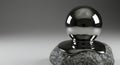 Metallic sphere balancing on rough granite rock surface Royalty Free Stock Photo