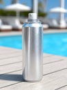Metallic spray can by a pool, bright and reflective in sunlight. Royalty Free Stock Photo