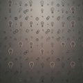 Metallic surface featuring embossed designs of light bulbs and Royalty Free Stock Photo