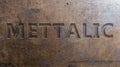 Metallic text effect displayed on a textured metal plate, showcasing a sleek and modern design. Royalty Free Stock Photo