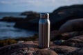 Metallic thermos on edge rock. Generate ai