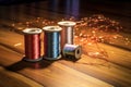 metallic thread spools with needle on a wooden surface Royalty Free Stock Photo