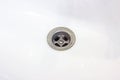 Metallic water drain hole in the white ceramic sink in the bathroom close up. Royalty Free Stock Photo