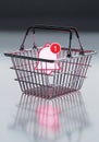 A metallic wire shopping basket with red plastic handles is positioned on a reflective surface. Royalty Free Stock Photo