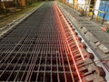 Metallurgical plant. Metal production process. The hot metal moves along rollers and cools down to take the finished shape. Royalty Free Stock Photo