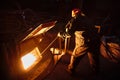 Metallurgist steelmaker takes a sample of liquid metal from a ladle.