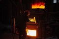 Metallurgist steelmaker takes a sample of liquid metal from a ladle.