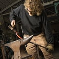 Metalsmith shaping metal.