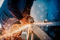 Metalworker cutting iron and metal with a rotary angle grinder and working, generating metal sparks Royalty Free Stock Photo